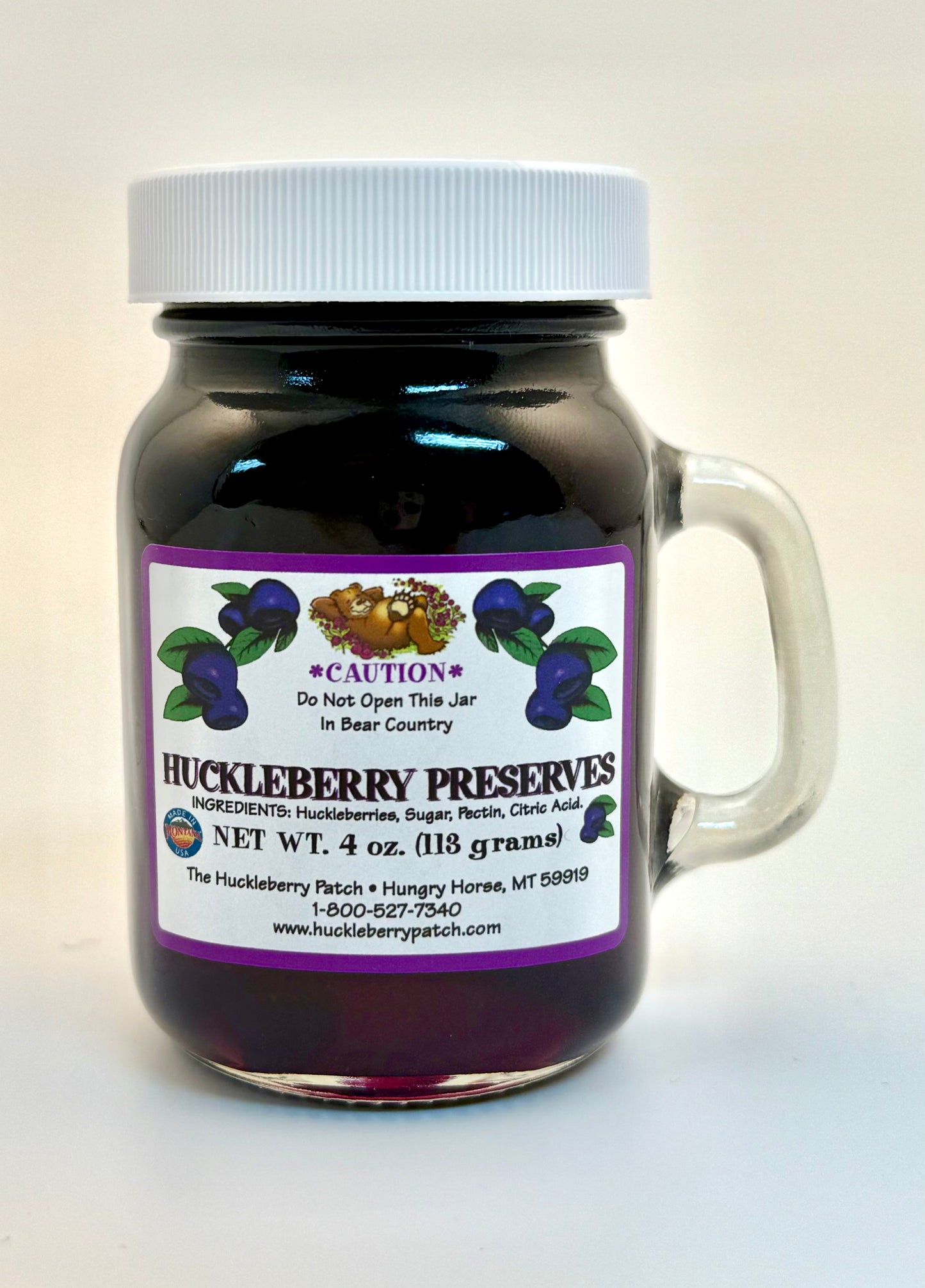 Standard 4oz jar of huckleberry preserves with front label