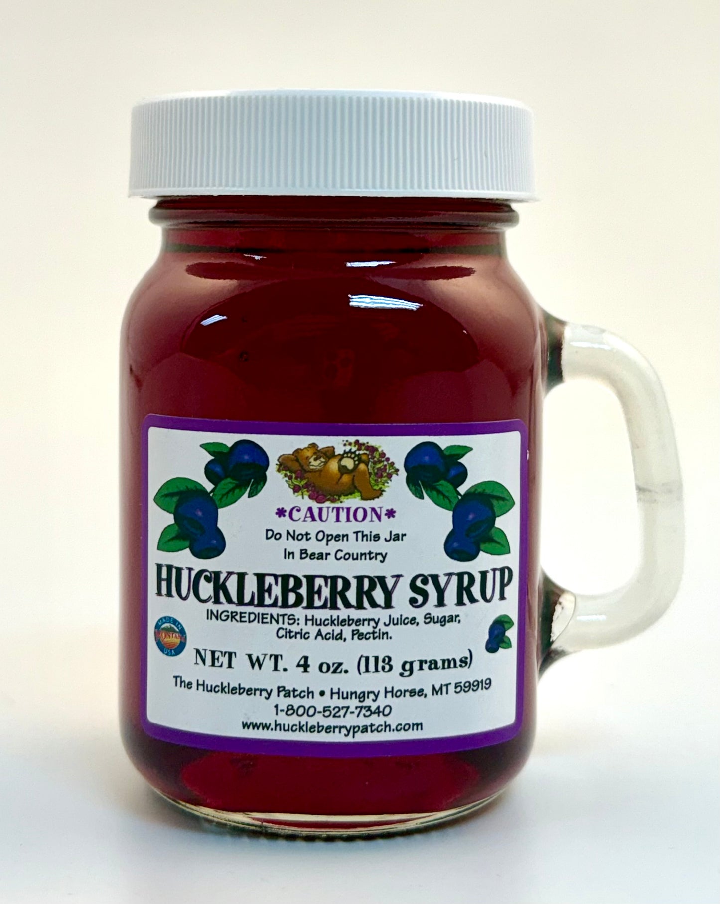 4oz glass bottle of huckleberry syrup with handle